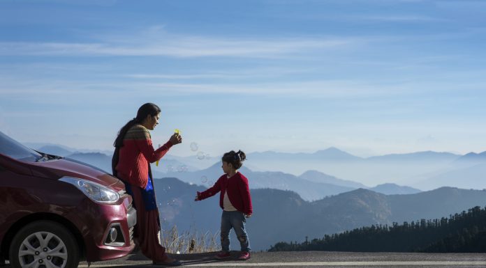 Mother and daughter on a road trip. Mother and daughter enjoying the road trip and winter vacation. Car travel vacation concept photo against Himalayan mountain in the background. Travel